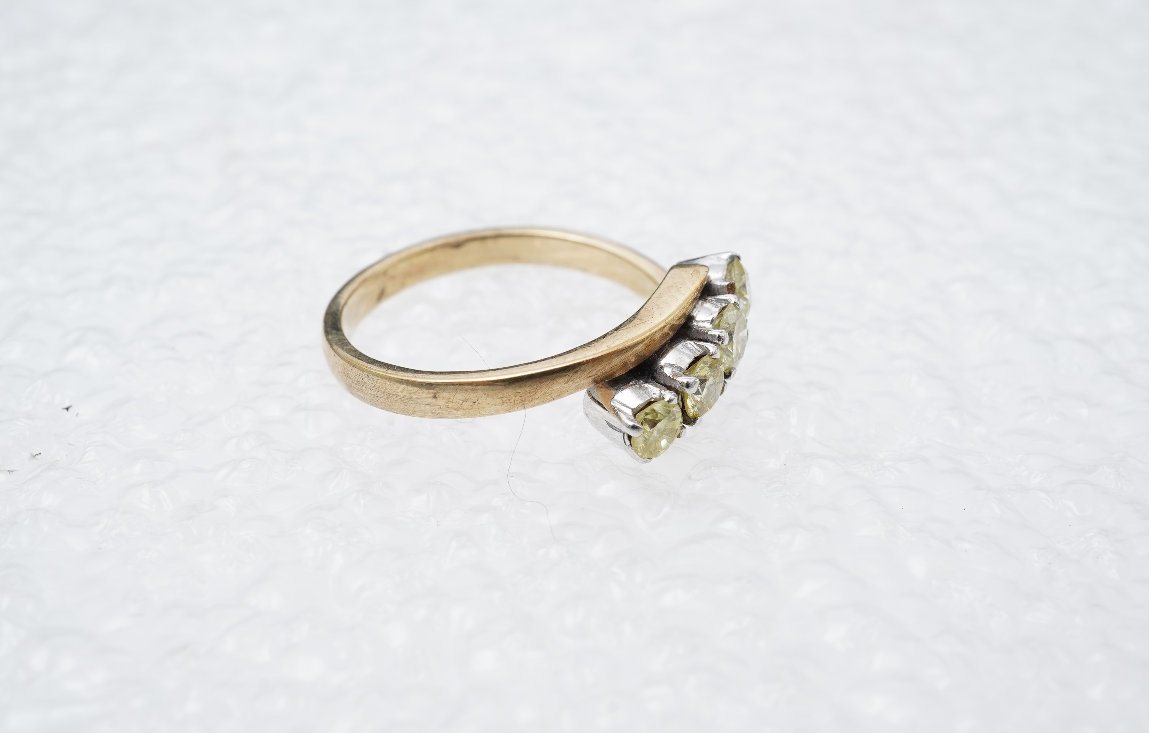A yellow diamond ring, claw-set with four brilliant-cut diamonds of yellow tint totalling approximately 0.40 carats, mounted in gold, gross weight approximately 2 grams